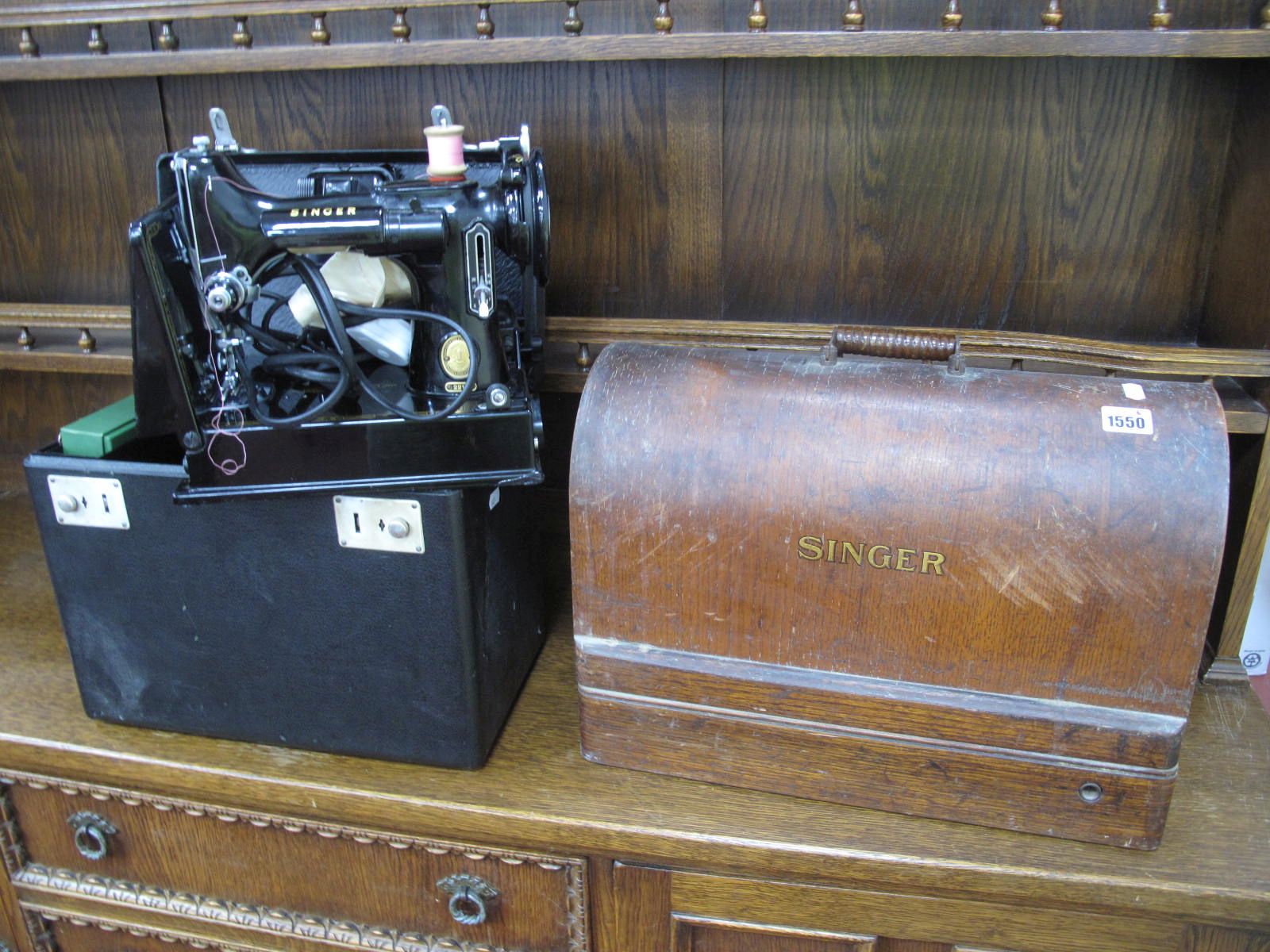 A Singer Sewing Machine, in oak dome topped case, an electric example in black early case, (untested