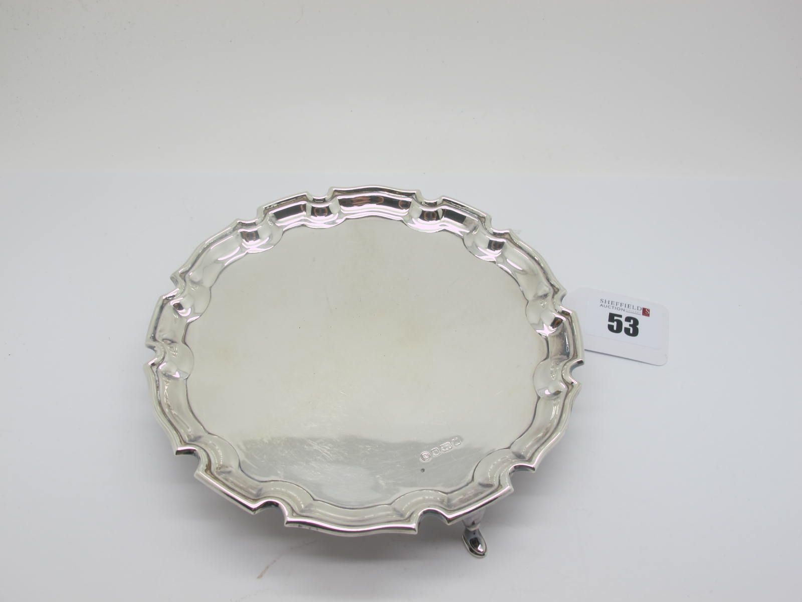 A Hallmarked Silver Card Tray, FH, Sheffield 1990 (rubbed), of shaped circular form, raised on three