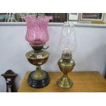 Two Oil Lamps; together with a XIX Century brass oil lamp, with a pink glass shade, one other