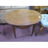 An Oak Oval Topped Bridge Table, with crib peg centre and suit marks to corners, on tapering legs,