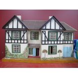 A Vintage Child's Dolls House, with a printed tiled roof, timber fronted painted tree and floral
