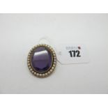 A Large Amethyst Single Stone Brooch, oval collet set within border of half pearls.
