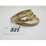 Four Modern Hinged Bangles, each with engraved decoration to the front, stamped "375". (4)