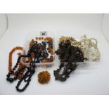 Amber Coloured and Jet Coloured Bead Necklaces, (damages); an amber coloured flowerhead brooch,