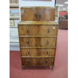A 1930's Walnut Cocktail Cabinet, with bowed upper cupboard doors, over four straight front drawers,