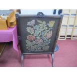 A XIX Century Rosewood Firescreen, with a woolwork tapestry of flowers, on splayed carved supports.