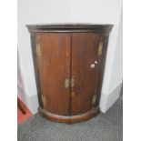 An XVIII Century Oak Bow Fronted Corner Cupboard, with reeded sides, two internal shelves, shaped