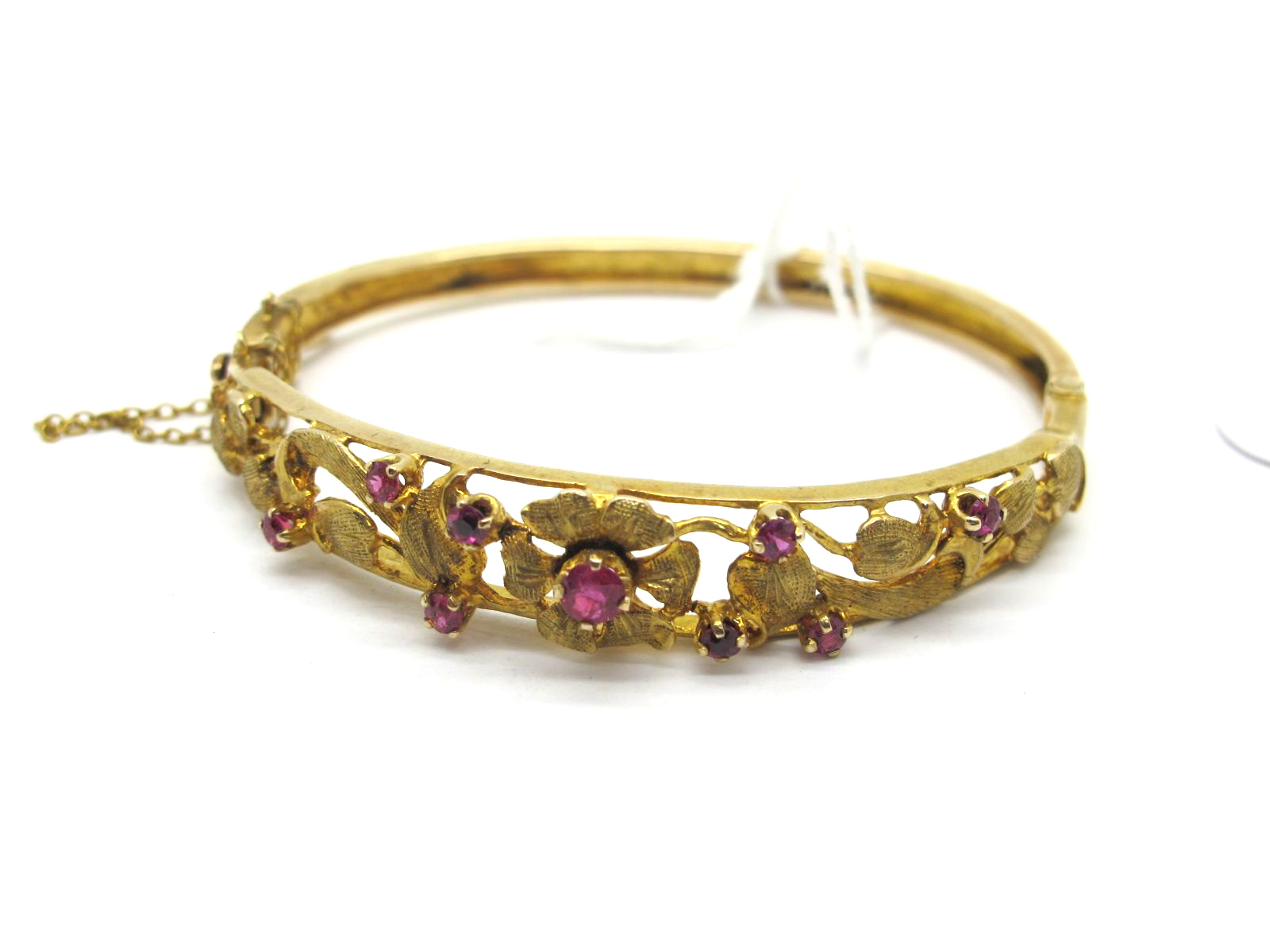 A Decorative 9ct Gold Hinged Bangle, of foliate openwork design to the front, with graduated claw