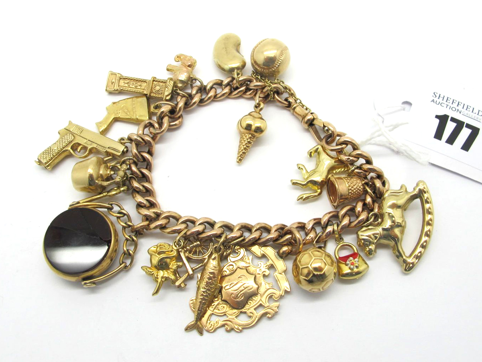 A Curb Link Charm Bracelet, to swivel clasp, suspending numerous assorted novelty charm pendants,