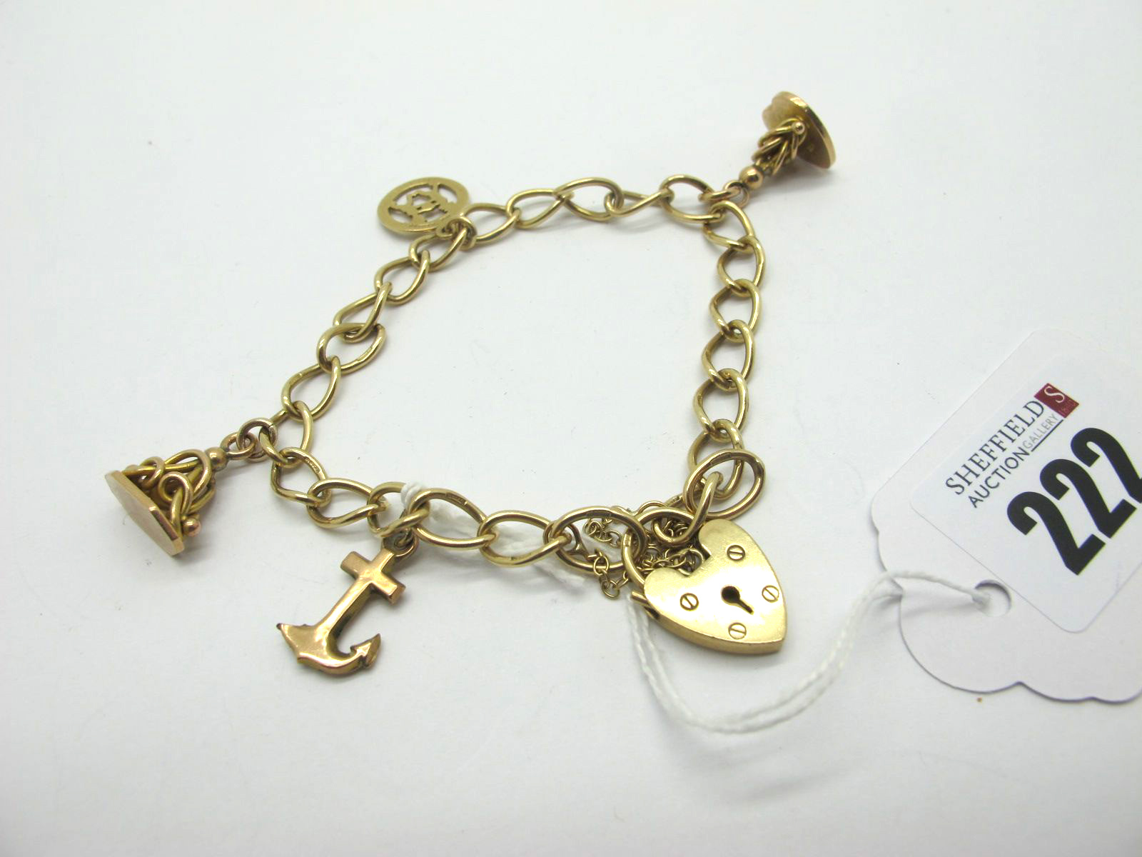 A 9ct Gold Curb Link Charm Bracelet, to 9ct gold heart shape padlock style clasp, suspending two