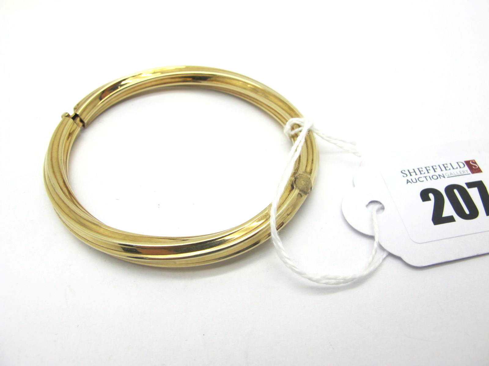 A Modern Hinged Bangle, of twist design, hinged to snap clasp, stamped "9ct" (15.5grams).