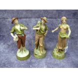 A Pair of Royal Dux Pottery Figures of Peasants, he holding a scythe, she scattering seeds from