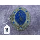 An Indian Lapis Oval Pendant, carved with a scorpion within elaborate borders and oval panels, set