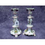 A Pair of Early XX Century German Porcelain Candlesticks, of scrolling rococo form encrusted with