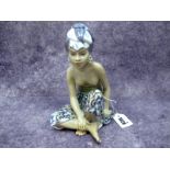 A Dahl Jensen Copenhagen Pottery Figure "Bali Woman", seated cross legged wearing a floral decorated