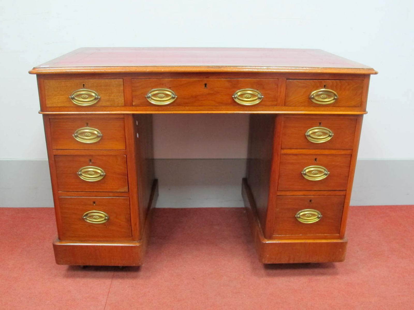 A XIX Century Walnut Pedestal Desk, with crossbanded top, red leather sciver and three top