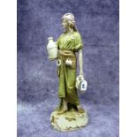 A Royal Dux Pottery Figure of a Female Water Carrier, carrying two urns, wearing flowing robes,