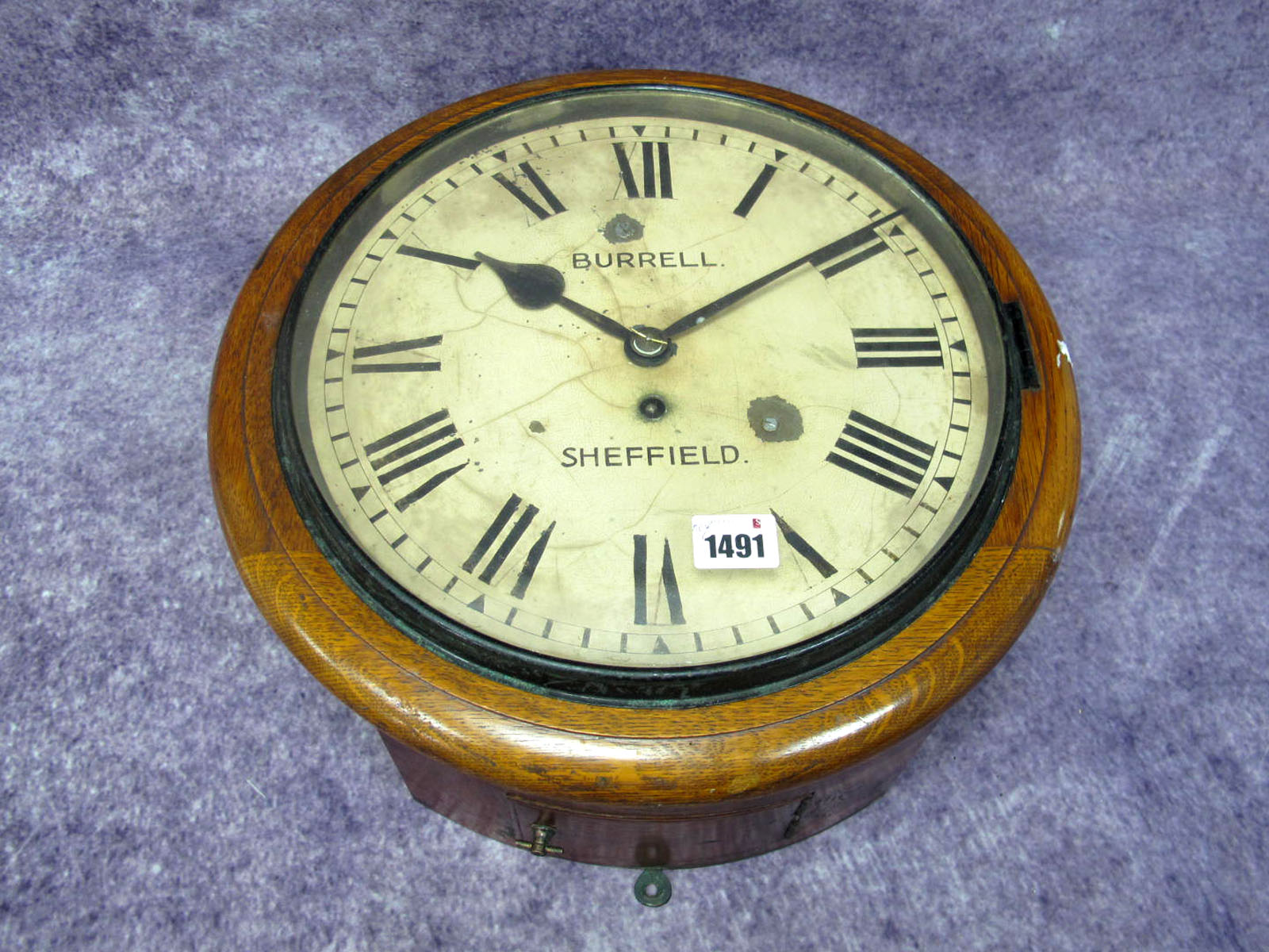 A Burrell Sheffield Oak Cased Wall Clock, the cream enamel dial with Roman numerals, winder present,