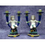 A Pair of Minton Majolica Pottery Late XIX Century Candlesticks, each modelled as a faun seated