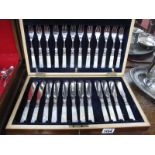 A Mahogany cased Set of Mother of Pearl Handled Knives and Forks, with key. (24)