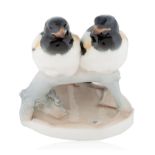 A CONTINENTAL PORCELAIN FIGURINE OF SWALLOWS ON A BRANCH, LATE 19TH-EARLY 20TH CENTURY