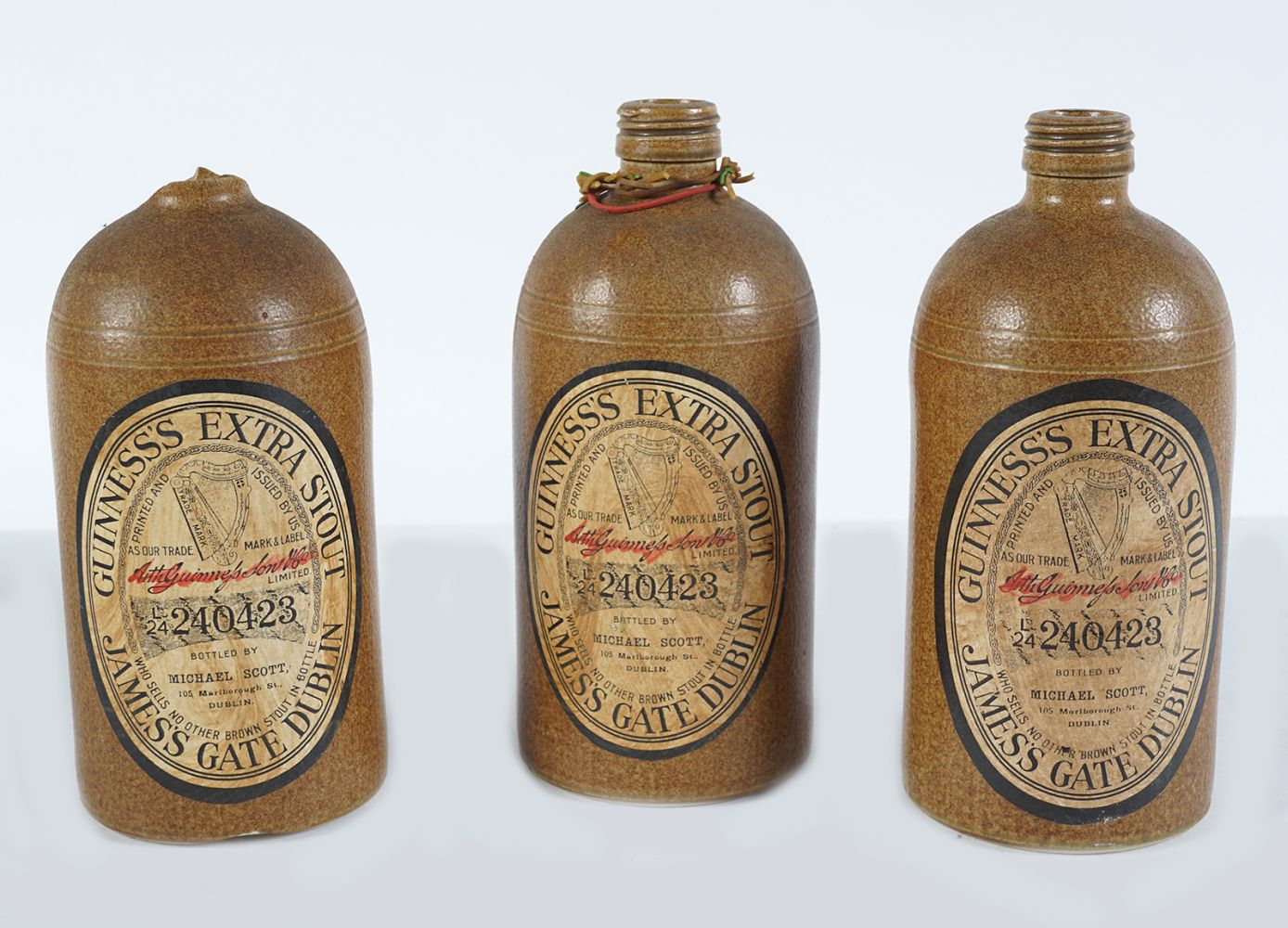 THREE ORIGINAL EARTHENWARE GUINNESS BOTTLES