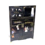 A CHINESE LAQUERED CUPBOARD Black lacquered wood with applied figures and flowers made of