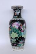 A BALUSTER FLOOR VASE China Porcelain with black ground and colourfully painted flowers.