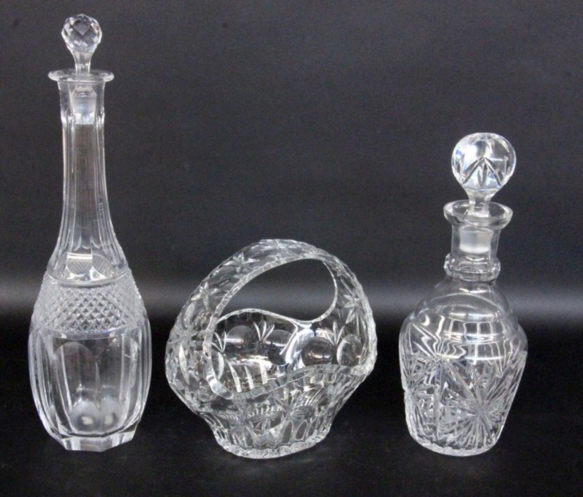 LOT 3 TEILE KRISTALLGLAS.2 Karaffen mit Stöpsel und Korb. Geschliffen.A LOT OF 3 CRYSTAL GLA