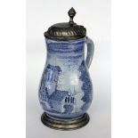 AN OLD FAIENCE JUG Pear shape with blue painting and pewter lid. Marked on the lid. 26 cm