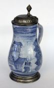 AN OLD FAIENCE JUG Pear shape with blue painting and pewter lid. Marked on the lid. 26 cm