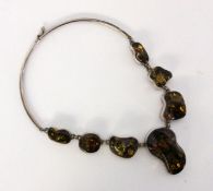 AN AMBER NECKLACE Silver with 7 large ambers with inclusions, approximately 2-5 cm. 40 cm