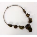 AN AMBER NECKLACE Silver with 7 large ambers with inclusions, approximately 2-5 cm. 40 cm