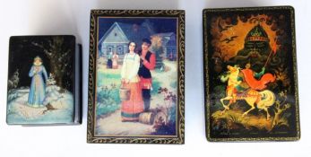 A LOT OF THREE RUSSIAN LACQUER BOXES 2 with colourfully painted fairy tale scenes, one