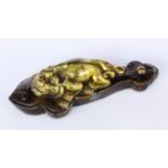 A LYING DRAGON China, Qing Bronze, gold-plated on brown patinated base. 15 cm long.