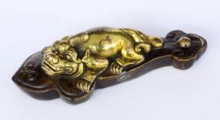 A LYING DRAGON China, Qing Bronze, gold-plated on brown patinated base. 15 cm long.