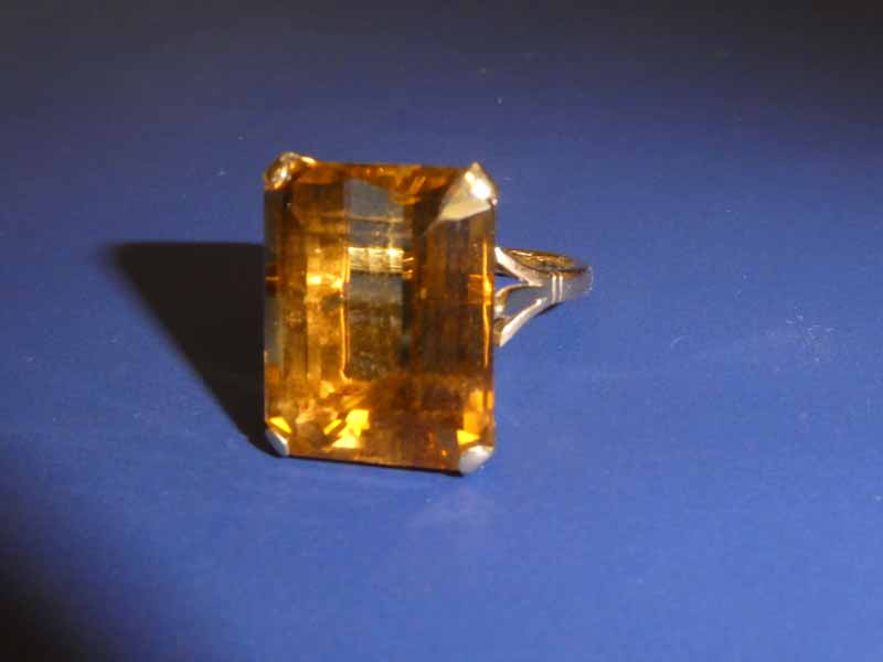 A 9ct gold Dress Ring set with a large rectangular Citrine, facetted edges, step cut, in a four claw