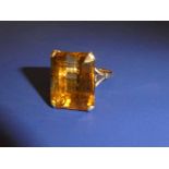 A 9ct gold Dress Ring set with a large rectangular Citrine, facetted edges, step cut, in a four claw