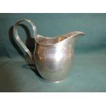 A George III early 19th century silver Creamer, oval form reeded strapwork handle and rim,