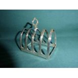 A mid century silver Four Slice Toast Rack, lancet shape with central carry handle, Sheffield