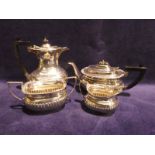An Edwardian silver Four Piece Tea Service, rounded rectangular form with gadrooned body, embossed