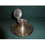 A large early 20th century silver Capstan Inkwell, circular form with hinged lid enclosing glass