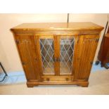 An Old charm style centrally glazed Bookcase with Linenfold side Cabinets 103.5cm height
