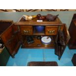 An Edwardian oak two-door Pipe Smokers Cabinet with 3 pipes