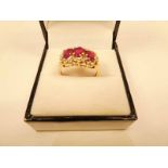 A 9k gold three stone ruby and chip diamond cluster ring, size O, 3.6g