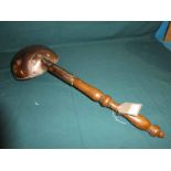 A 19th century copper Ladle, 22cm diameter with 50cm turned wooden handle