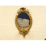 An early 19th century gilt gesso Girandole Mirror, oval glass within foliate decorated frame with