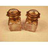 A pair of square base gilt top scent bottles, the caps unset with hand painted porcelain