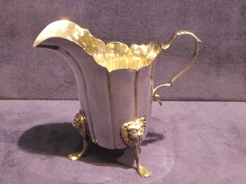 A good quality Edwardian silver Cream Jug, helmet shape with S scroll handle, standing on three