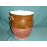 A terracotta twin handle Crock, brown glazed upper portion, 38cm high